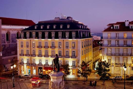 Corner hotel building on a sloping city street with wet paving stones